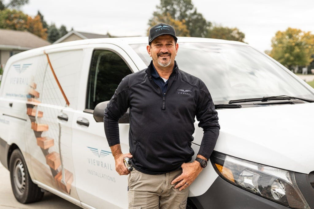 A Certified Viewrail Installer stands confidently in front of a Viewrail van