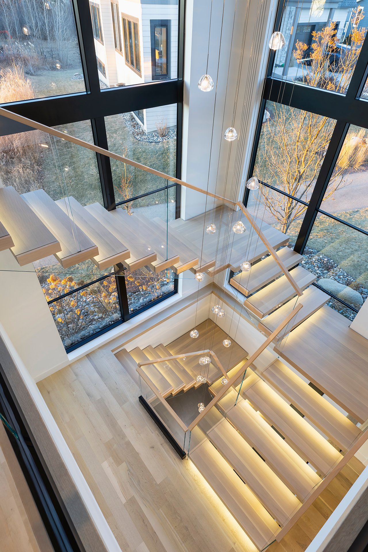 Top-down image of FLIGHT mono stairs with Vedera railing, connecting second floor to first and lower levels.