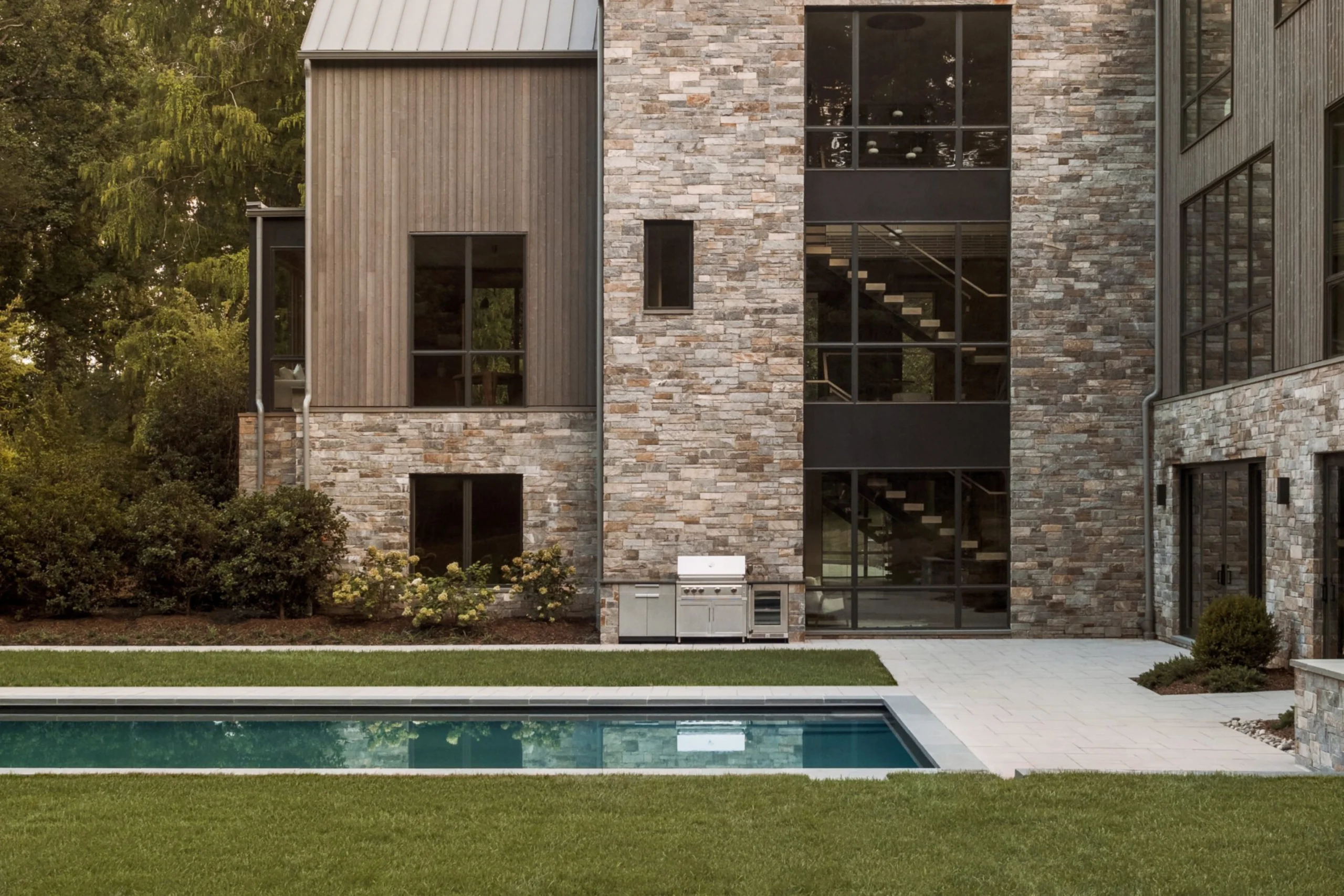 A photo of a large three-story home overlooking a patio and pool outside, with FLIGHT Mono clearly visible through the large windows on the back of the house.