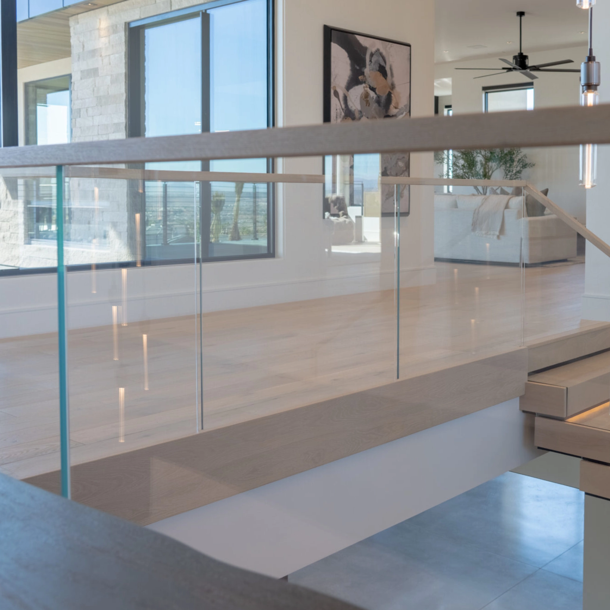 A Hidden Side Mount glass railing system on a landing above a FLIGHT Stack stair system.